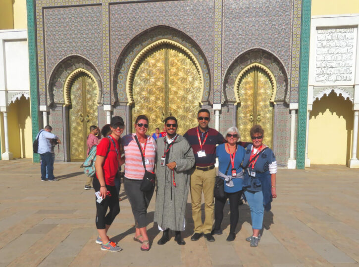 Group posing in front of ornate golden doors